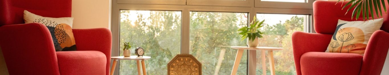 Heller Raum für Gruppentherapie mit gelben Stühlen und großen Fenstern